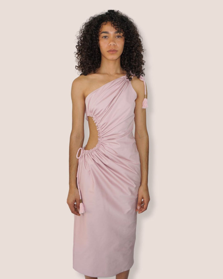 Robe longue/midi drapée asymétrique rose pâle "Danse des Nymphes" , une épaule, découpe et laçage à la taille avec pompons à embouts bronze - Meldesign 2025